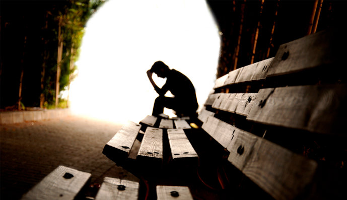 Foto: Teenager-Junge sitzt in einem Tunnel auf Holzplanken.