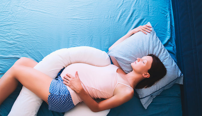 Foto: Schwangere Frau liegt auf dem Bett