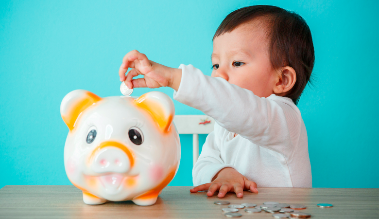 Foto: Baby wirft Münzen in ein Sparschwein